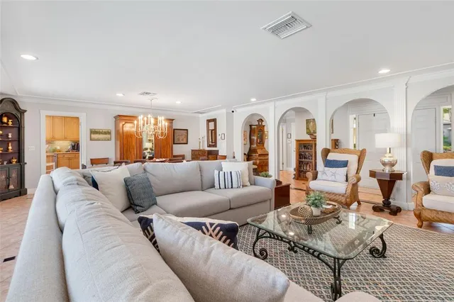 a living room with furniture kitchen view and large windows