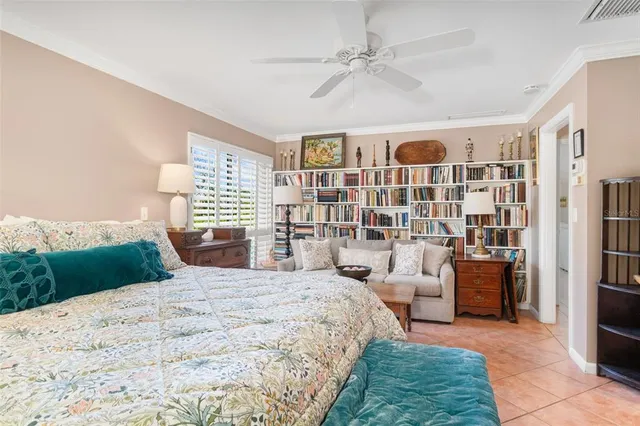 a spacious bedroom with a bed and a bookshelf with wooden floor