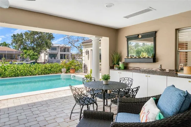 a view of a patio with table and chairs potted plants and a large tree