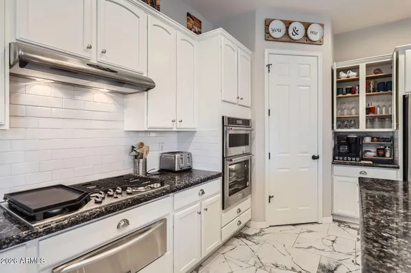 a kitchen with granite countertop a stove and a refrigerator