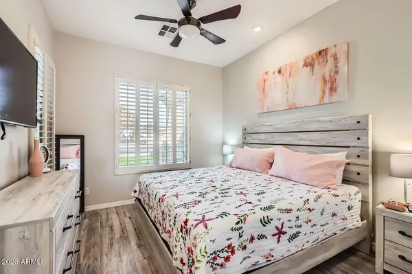 a bedroom with a large bed and a flat tv screen on dresser