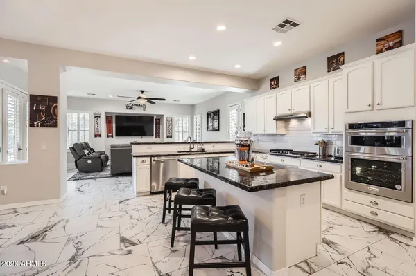 a kitchen with stainless steel appliances kitchen island granite countertop a stove sink and cabinets