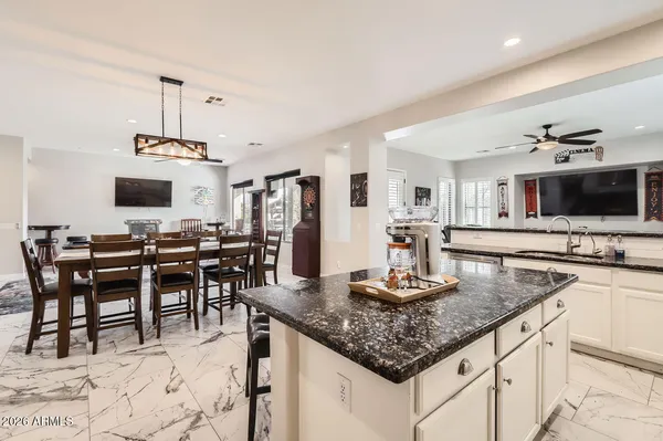 a kitchen with kitchen island granite countertop a stove and a sink