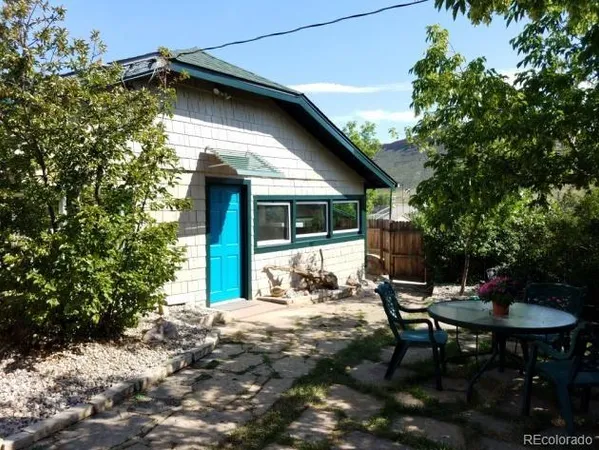 a backyard of a house with table and chairs