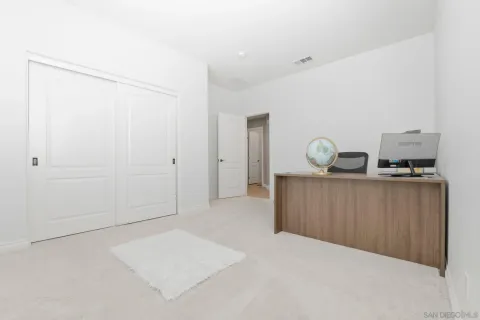 a bedroom with a chair a flat screen tv and a couch
