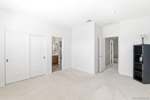 a bedroom with a large bed and a chandelier fan