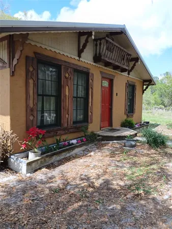 a view of a house with potted plants and a chair