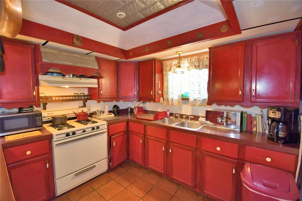 760 McClellan Road Frostproof, FL 33843 - Photo 25 of 72 a kitchen with stainless steel appliances a stove sink and wooden cabinets
