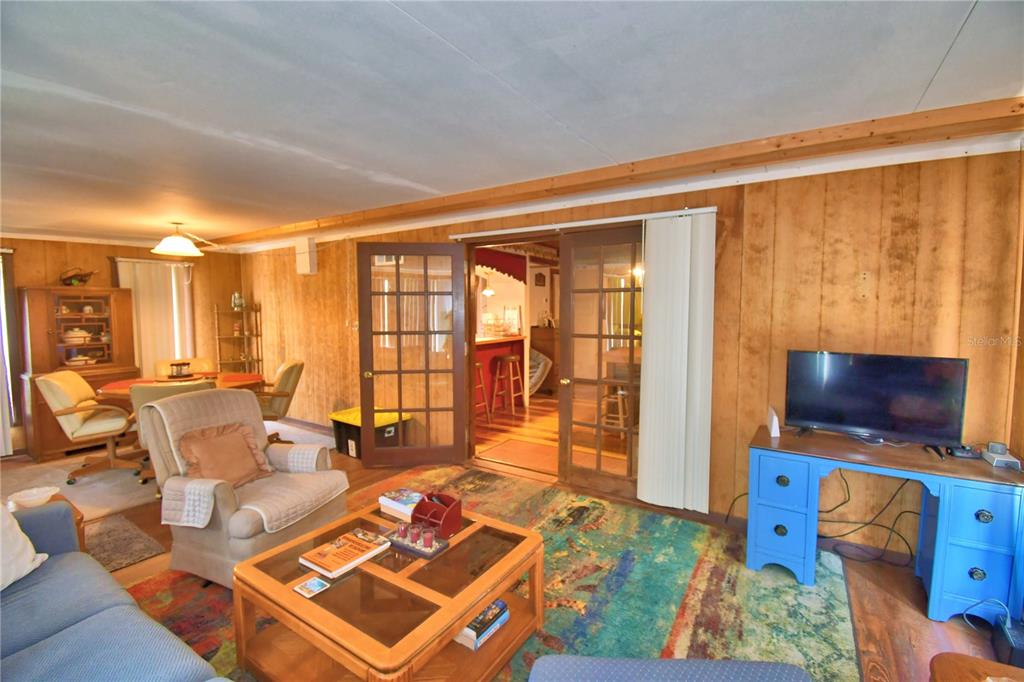 760 McClellan Road Frostproof, FL 33843 - Photo 29 of 72 a living room with furniture a flat screen tv and a floor to ceiling window
