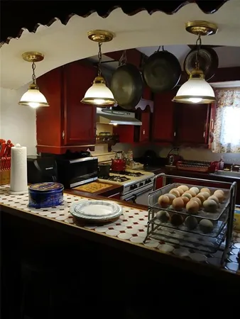 a kitchen with a stove and a wooden floor