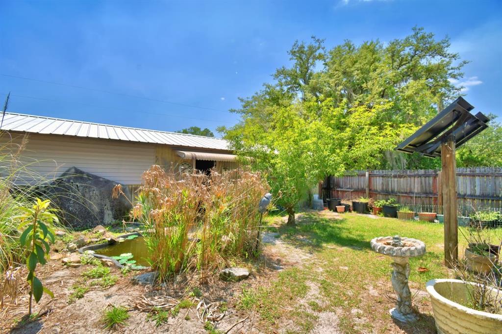 760 McClellan Road Frostproof, FL 33843 - Photo 67 of 72 a backyard of a house with table and chairs a barbeque
