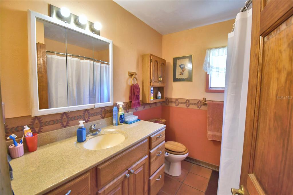 760 McClellan Road Frostproof, FL 33843 - Photo 10 of 72 a bathroom with a granite countertop sink toilet and shower