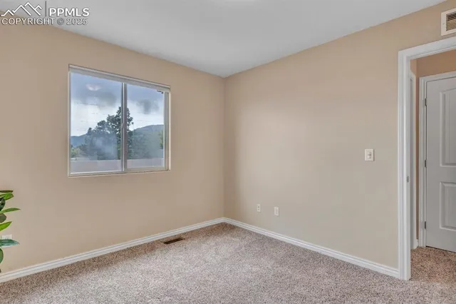 a view of a small space with wooden floor and a window