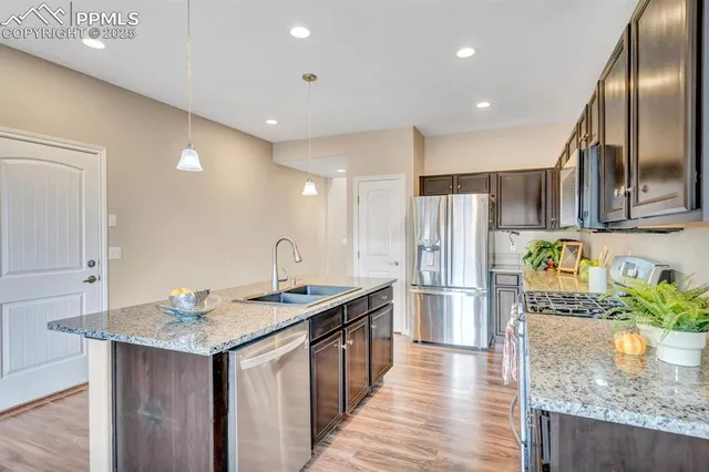 a kitchen with stainless steel appliances granite countertop a sink refrigerator and microwave