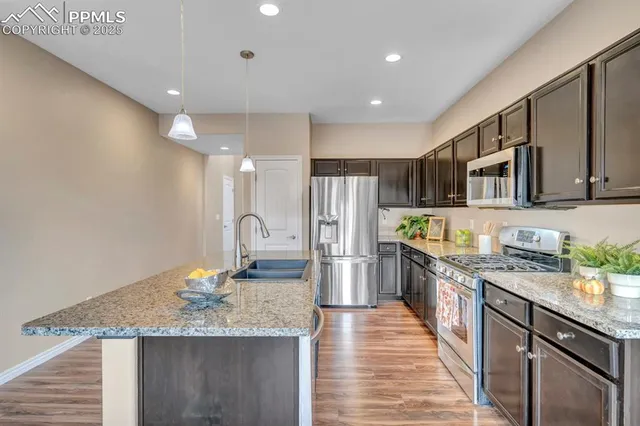 a kitchen with stainless steel appliances granite countertop a sink stove and refrigerator