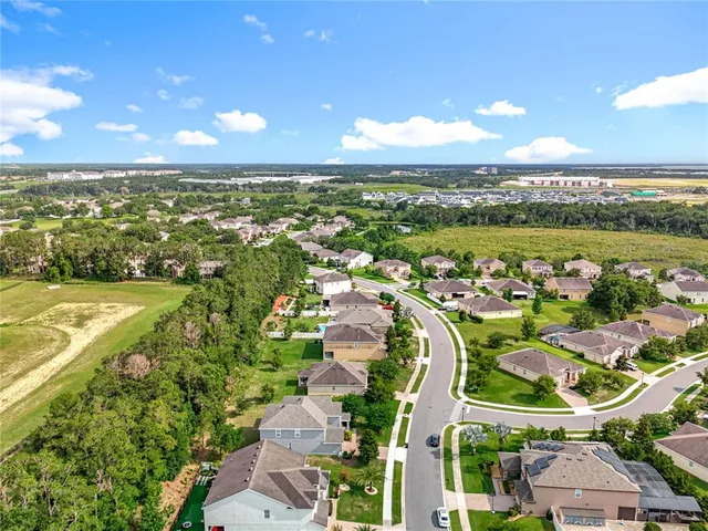 aerial view of a house with a garden and large trees