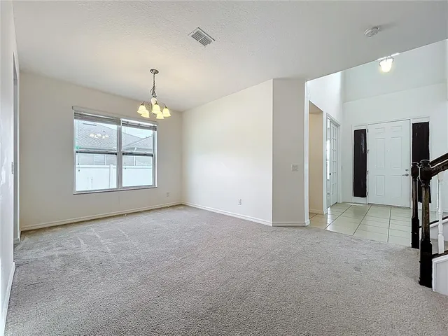 an empty room with windows and chandelier