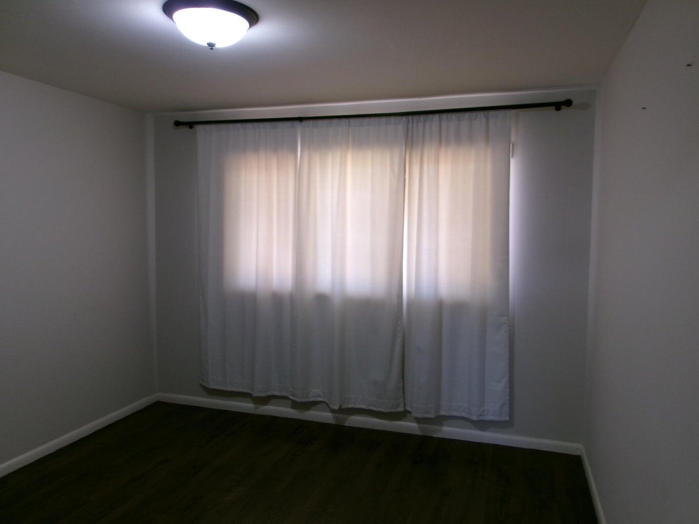 1201 Borger Plainview, TX 79072 - Photo 13 of 22 an empty room with wooden floor and windows