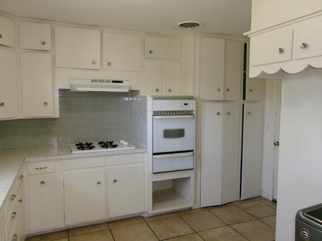 1201 Borger Plainview, TX 79072 - Photo 6 of 22 a kitchen with white cabinets and white appliances