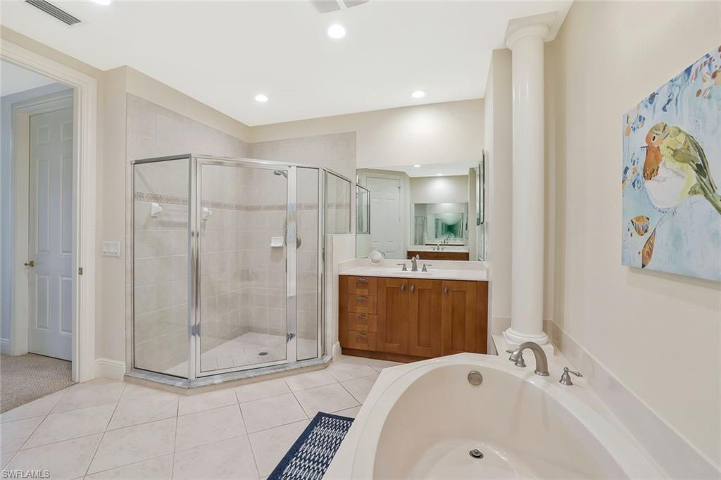9209 Museo Circle, Unit 102 Naples, FL 34114 - Photo 11 of 18 a bathroom with a tub a sink and mirror