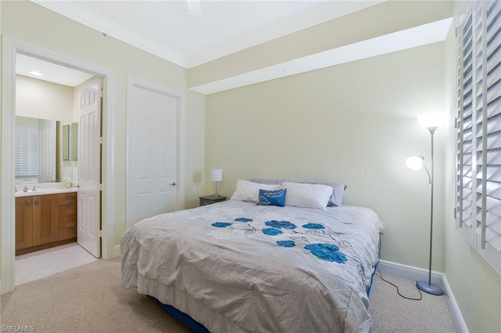 9209 Museo Circle, Unit 102 Naples, FL 34114 - Photo 12 of 18 a bedroom that has a bed and a table in it