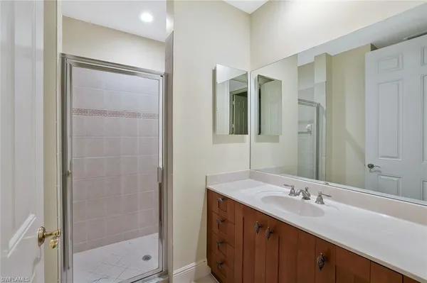 a bathroom with a double vanity sink mirror and shower