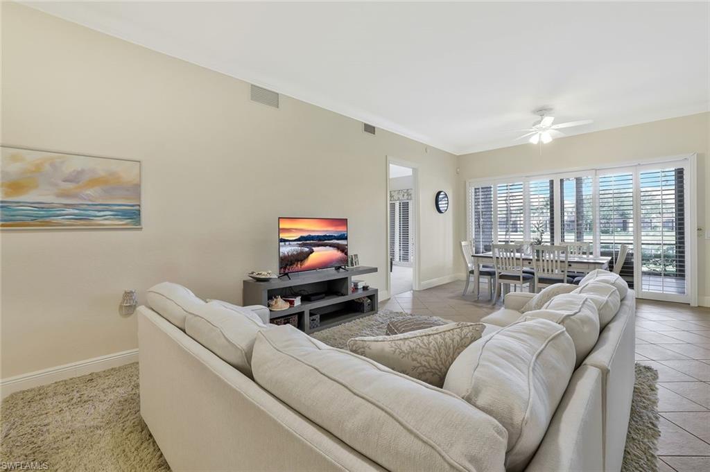 9209 Museo Circle, Unit 102 Naples, FL 34114 - Photo 2 of 18 a living room with furniture and a flat screen tv