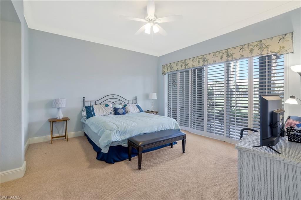 9209 Museo Circle, Unit 102 Naples, FL 34114 - Photo 8 of 18 a bedroom with a bed lamp and a large window
