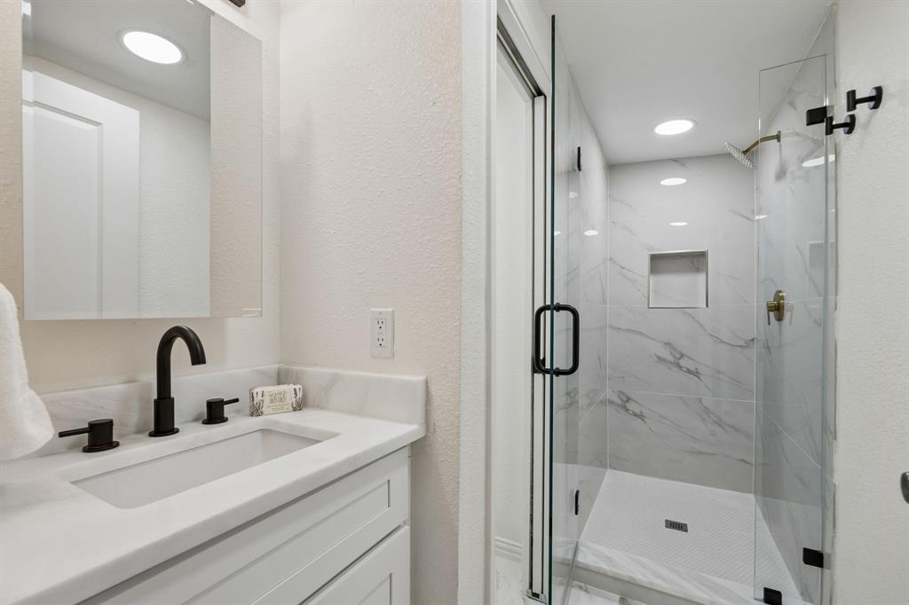 806 North Ruddell Street Denton, TX 76209 - Photo 11 of 26 a bathroom with a shower sink and mirror