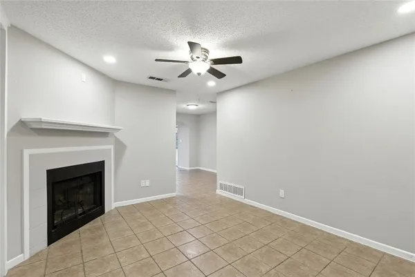 an empty room with windows and fireplace