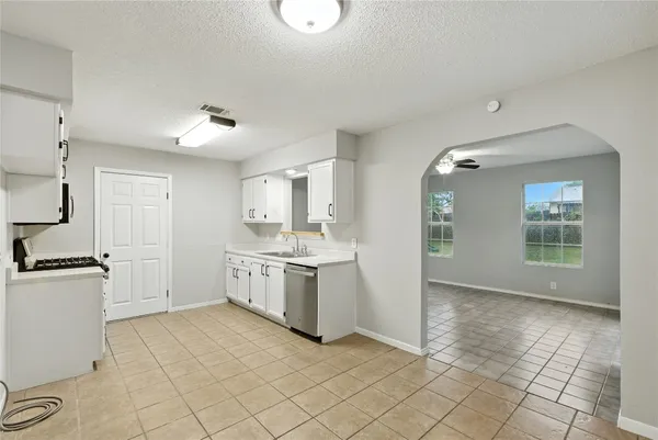 a large white kitchen with a stove a sink dishwasher and a refrigerator