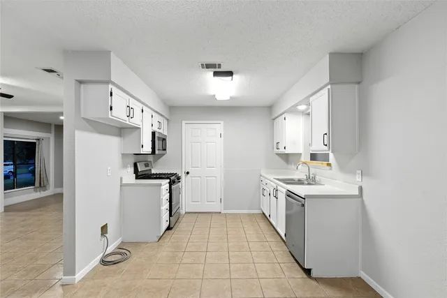 a kitchen with cabinets and stainless steel appliances