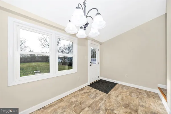 a view of a livingroom with a chandelier fan and windows