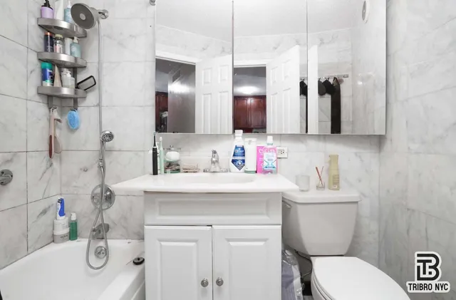 a bathroom with a sink toilet vanity and shower