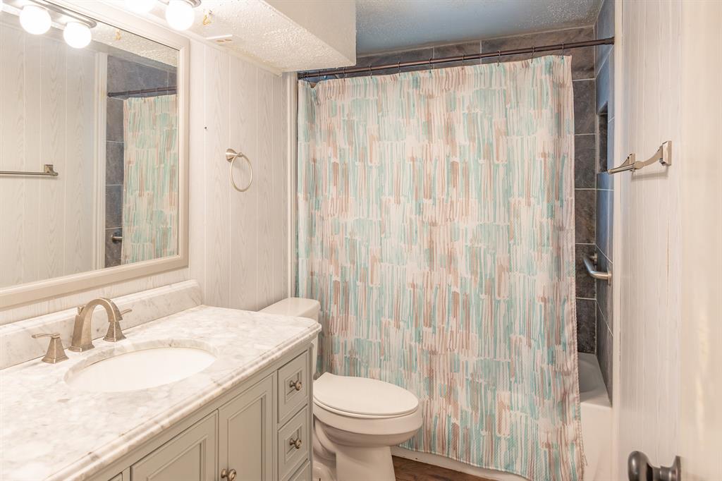 925 Angies Crossing Tool, TX 75143 - Photo 16 of 25 a bathroom with a granite countertop sink toilet and a mirror