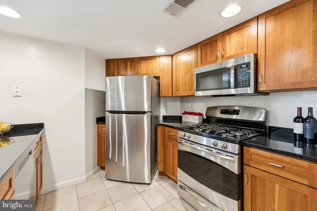 a kitchen with granite countertop cabinets stainless steel appliances and a counter space