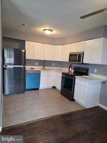 a kitchen with stainless steel appliances a stove a sink and a refrigerator