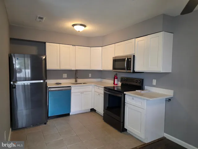 a kitchen with stainless steel appliances granite countertop a stove a sink dishwasher a refrigerator and a microwave
