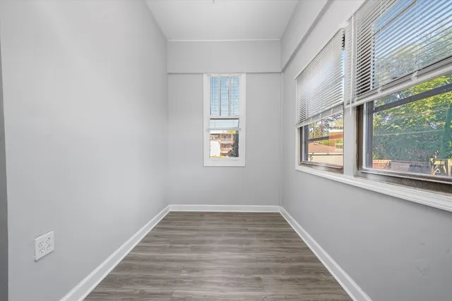 a view of a room with wooden floor and windows