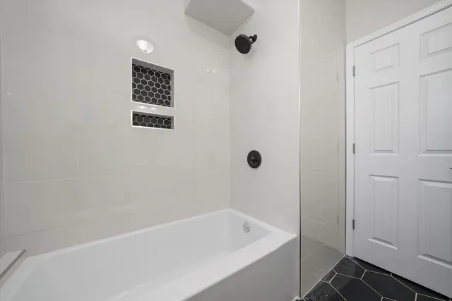 a white bath tub sitting next to a shower
