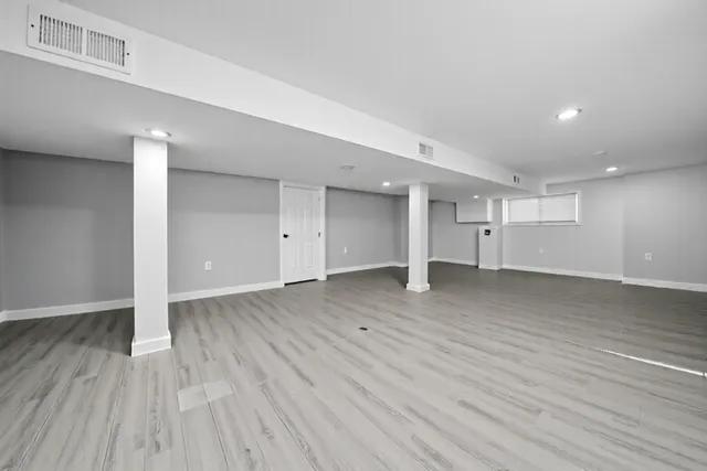 a view of an empty room with wooden floor