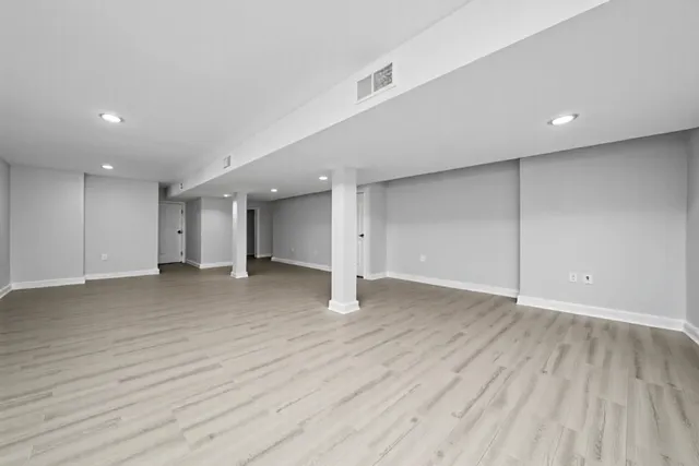 a view of an empty room with wooden floor