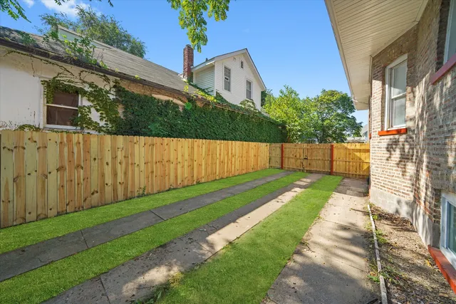 a view of backyard with potted plants and wooden fence