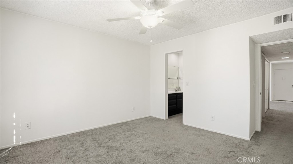 833 Cinnamon Lane, Unit 4 Duarte, CA 91010 - Photo 22 of 34 an empty room with a ceiling fan and a bathroom