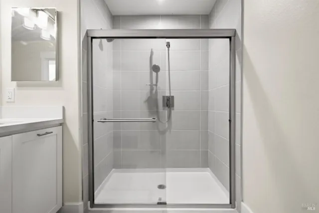 a bathroom with a shower sink vanity and mirror