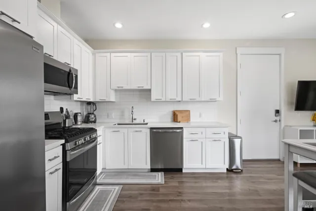 a kitchen with white cabinets and stainless steel appliances