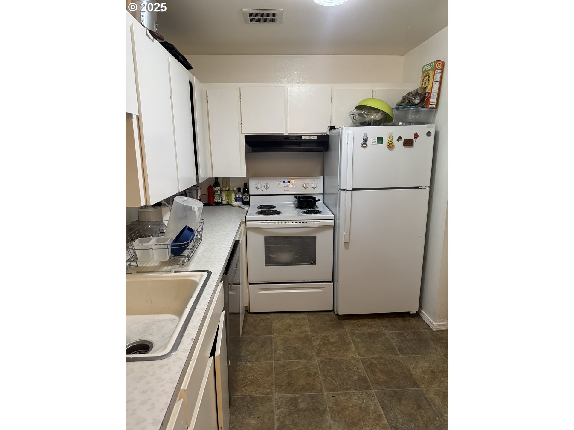 3398 Southwest 125th Avenue Beaverton, OR 97005 - Photo 22 of 25 a kitchen with a sink a refrigerator and cabinets