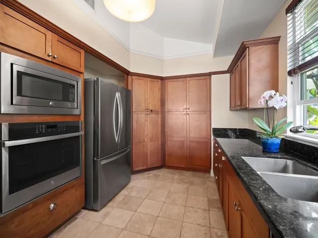 a kitchen with granite countertop a sink and stainless steel appliances