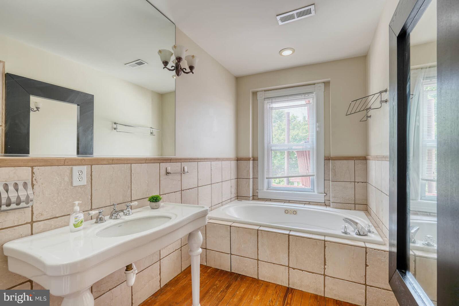 1402 Light Street Baltimore, MD 21230 - Photo 29 of 60 a spacious bathroom with a tub sink and mirror