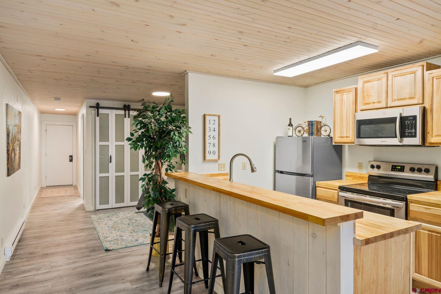 35 Emmons Road, Unit A Crested Butte, CO 81225 - Photo 7 of 28 a kitchen that has a microwave a stove and a refrigerator